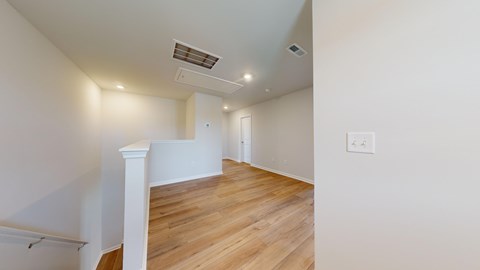 A room with wooden flooring and white walls.
