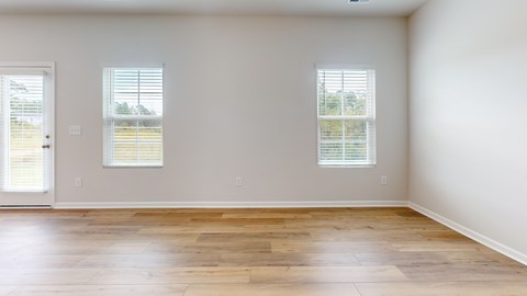 A room with wooden floors and two windows.