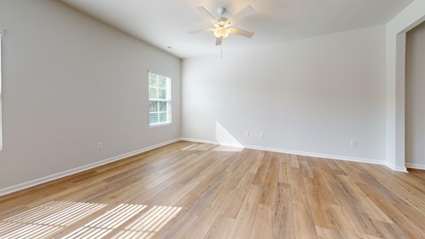A room with wooden flooring and a ceiling fan.