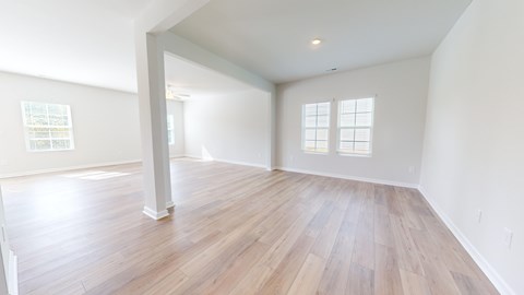 A room with wooden flooring and white walls.