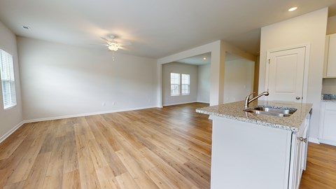 A kitchen with a granite countertop and wooden flooring.
