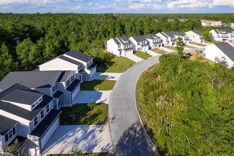 A bird's eye view of a residential area with houses and a winding road.