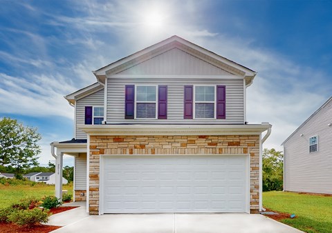 A house with a white garage door and purple window shutters.