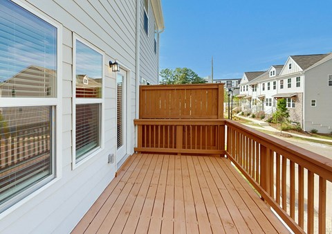 A wooden deck with a bench and a window.