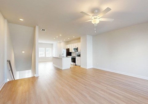 A spacious room with a ceiling fan and wooden flooring.