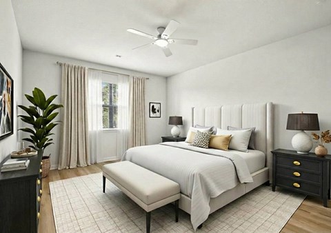 A bedroom with a large bed, a bench, and a ceiling fan.