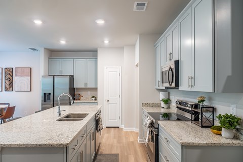 A modern kitchen with granite countertops and stainless steel appliances.