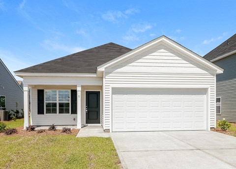 A white house with a black door and a grey roof.