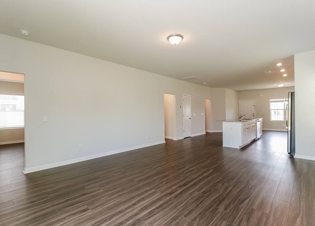 A large empty room with wooden floors and white walls.