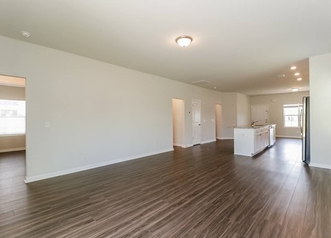 A large empty room with wooden floors and white walls.