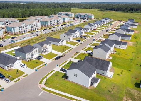 A bird's eye view of a residential area with houses and cars.