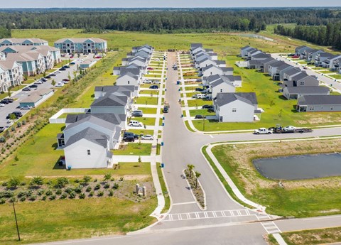 A row of houses with a lake in the front yard.