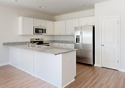 A kitchen with white cabinets and a granite countertop.
