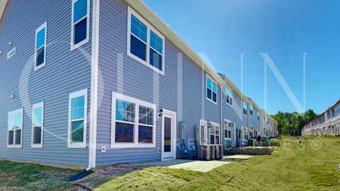 a row of houses with blue and white siding and grass