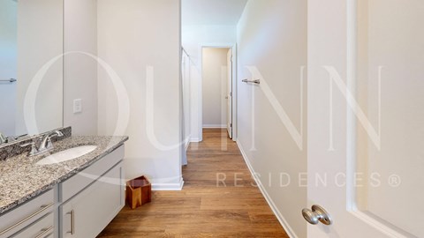 a bathroom with a sink and a mirror and a hallway