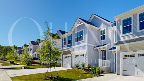a row of white houses with trees in front of them