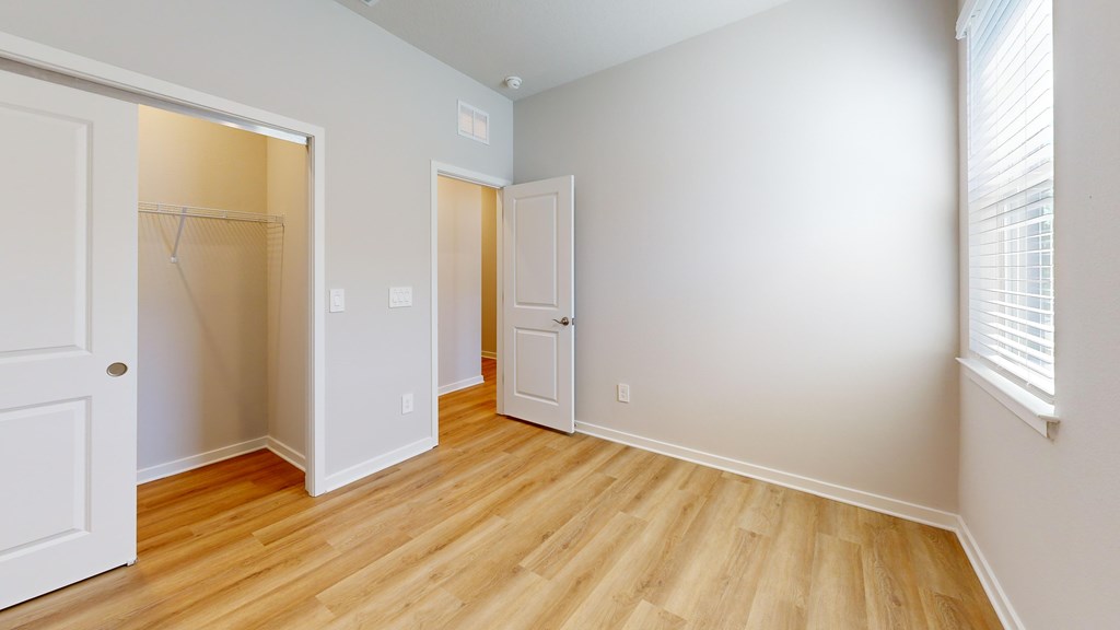 A room with a white door and a wooden floor.