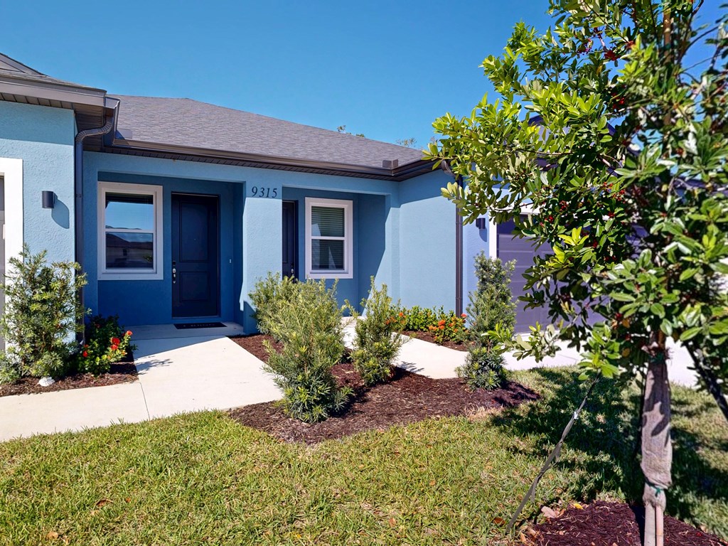 A blue house with a white door and windows.