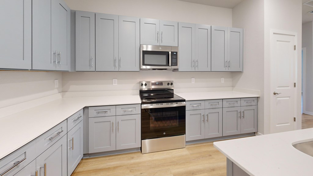 A kitchen with a stove top oven and a microwave above it.
