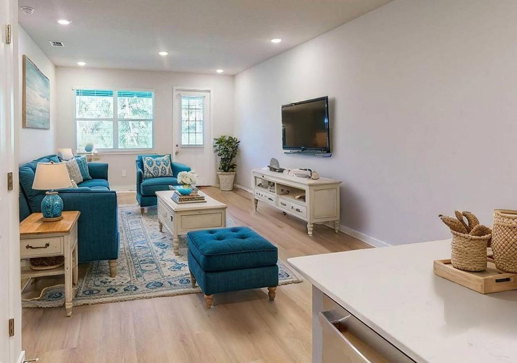 A living room with a blue couch and a white entertainment center.