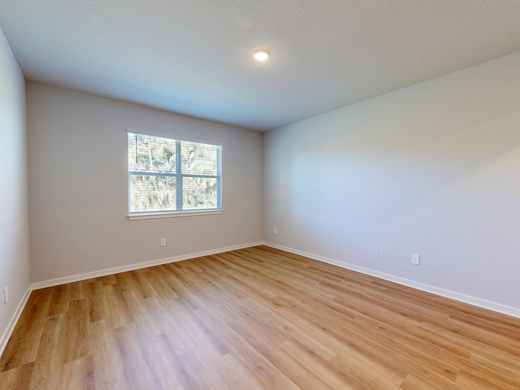 A room with wooden flooring and a window.