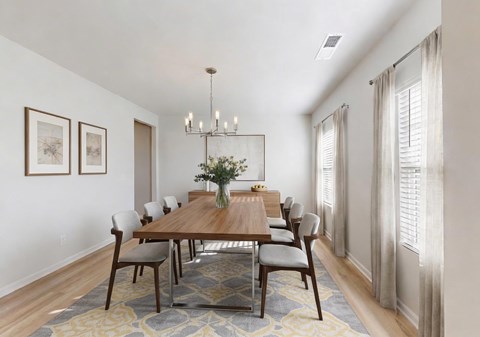A dining room with a wooden table and chairs.