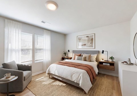 A well-lit bedroom with a large bed and a chair by the window.
