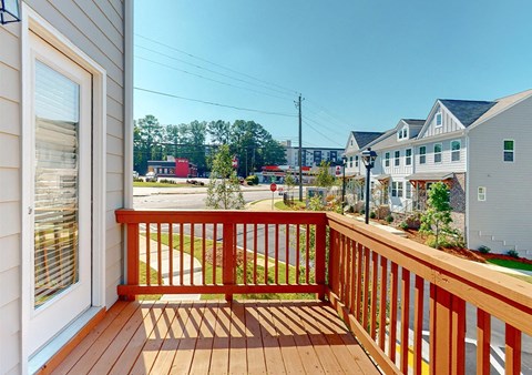 A wooden deck with a red railing and a white door.
