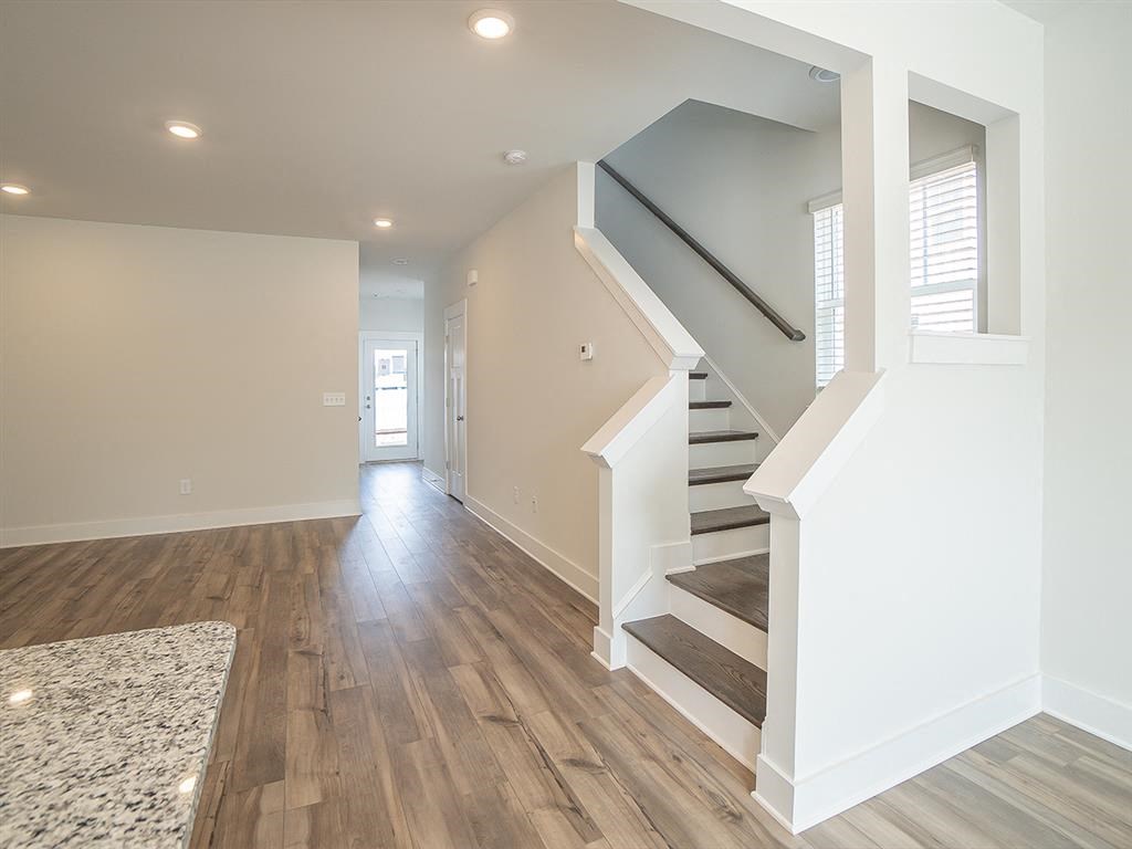 A spacious hallway with a staircase and a marble floor.
