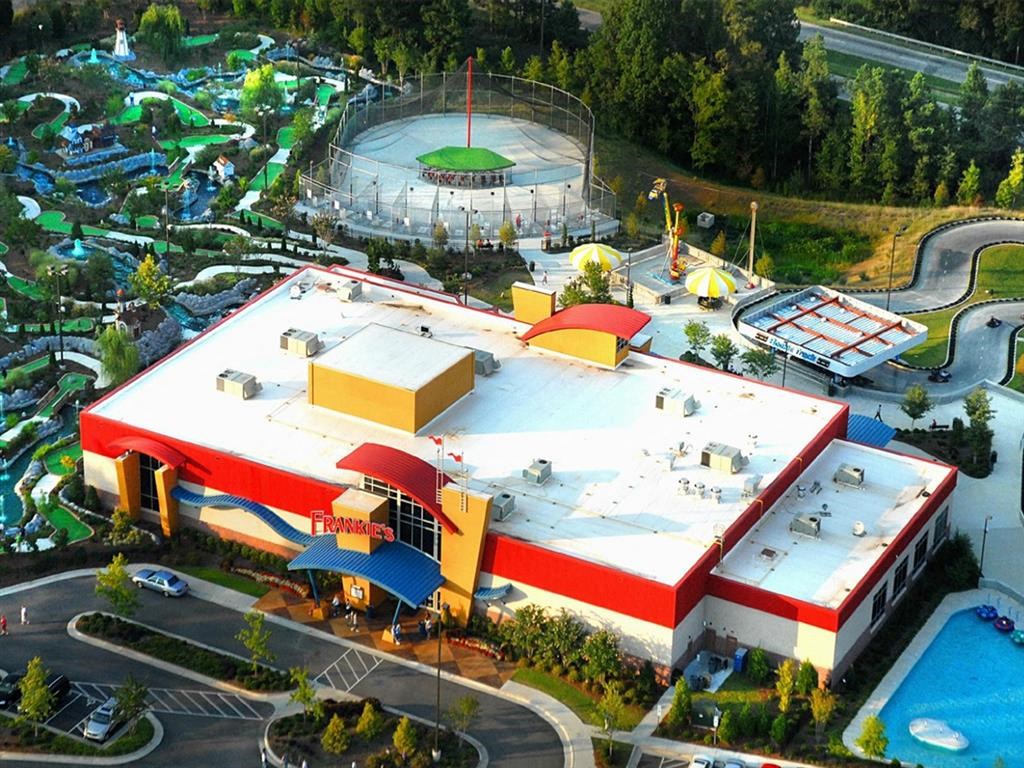 A large building with a red and white exterior and a pool in front.