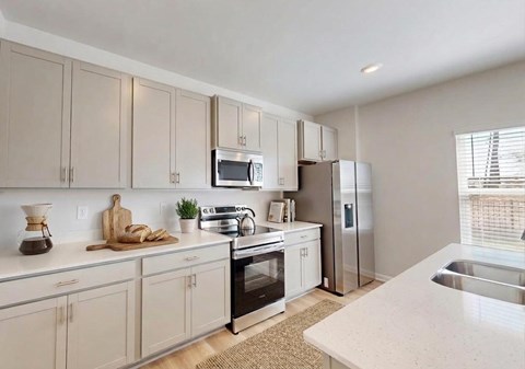 A kitchen with white cabinets and appliances.