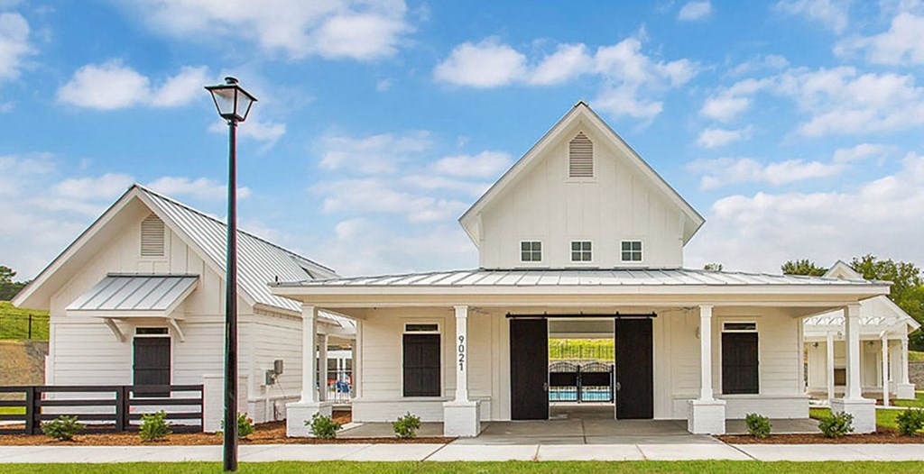 the front of a white house with a street light