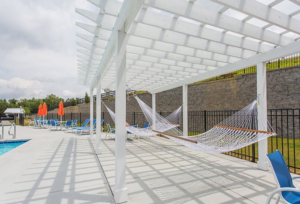 a group of hammocks on a patio next to a pool