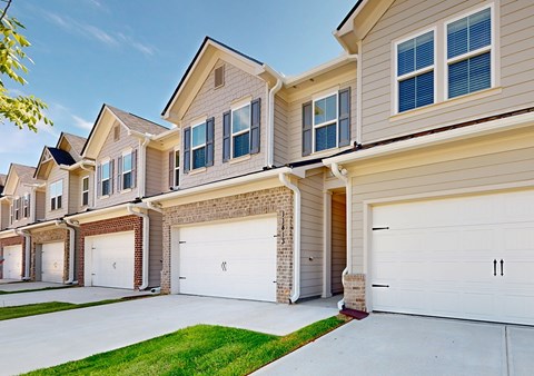A row of houses with garages and driveways.