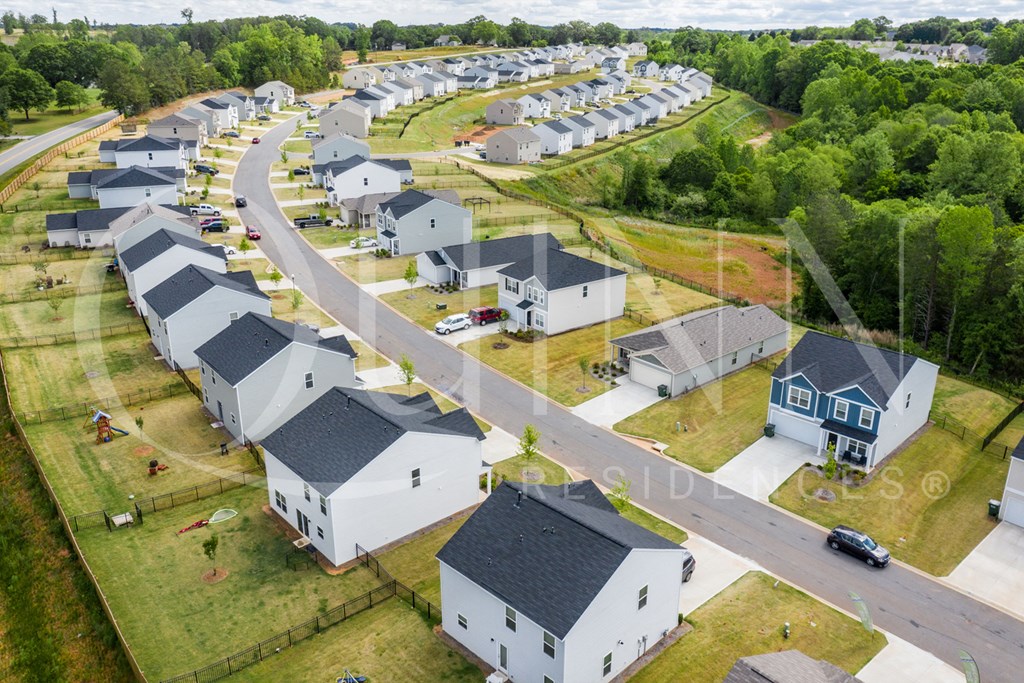 an aerial view of a neighborhood of houses with cars parked