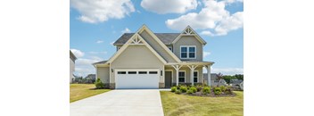 A two-story house with a garage and a covered porch.