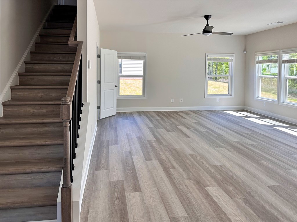 A room with a staircase and a ceiling fan.