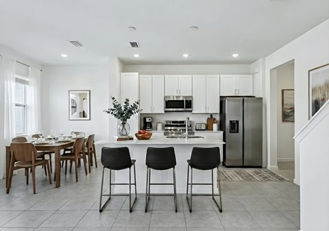 A modern kitchen with a dining table and chairs.