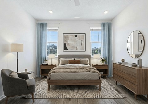 A well-lit bedroom with a large bed, a chair, and a painting on the wall.