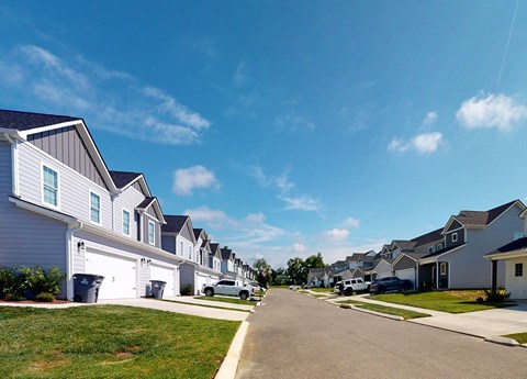A row of houses with a car parked on the street.