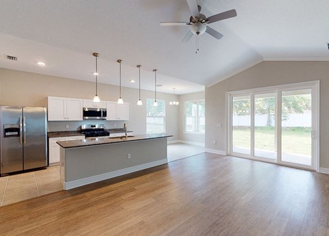 an open kitchen and living room with a ceiling fan