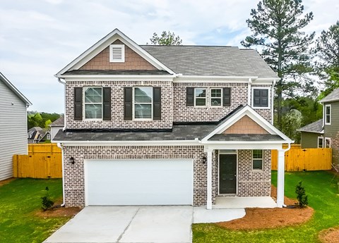 A two-story house with a garage and a covered entryway.