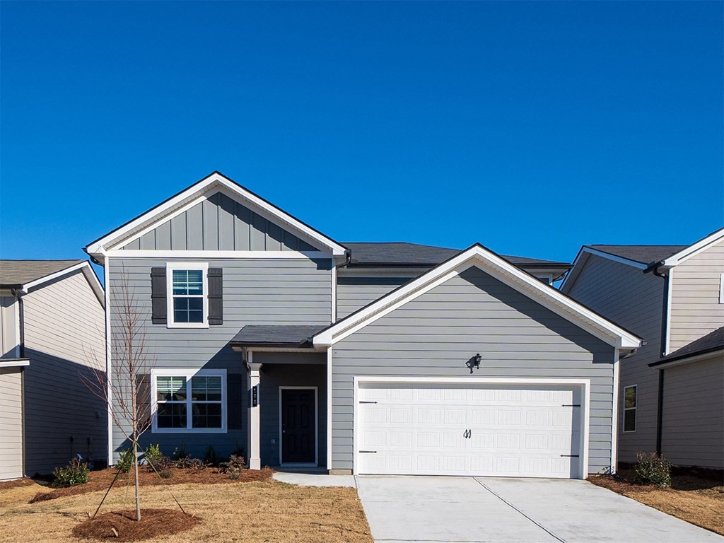 A house with a grey facade and a white garage door.