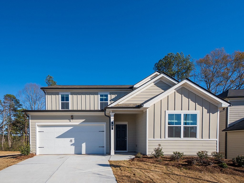 A modern house with a garage door and a driveway.