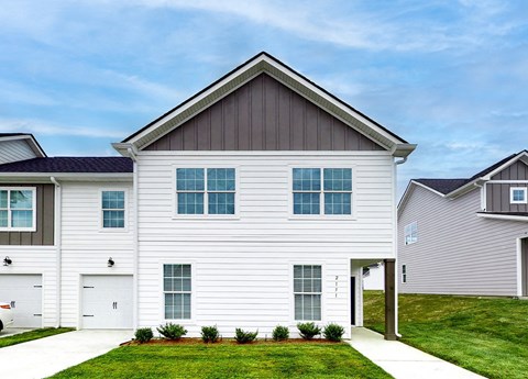 A modern house with a white facade and a grey roof.