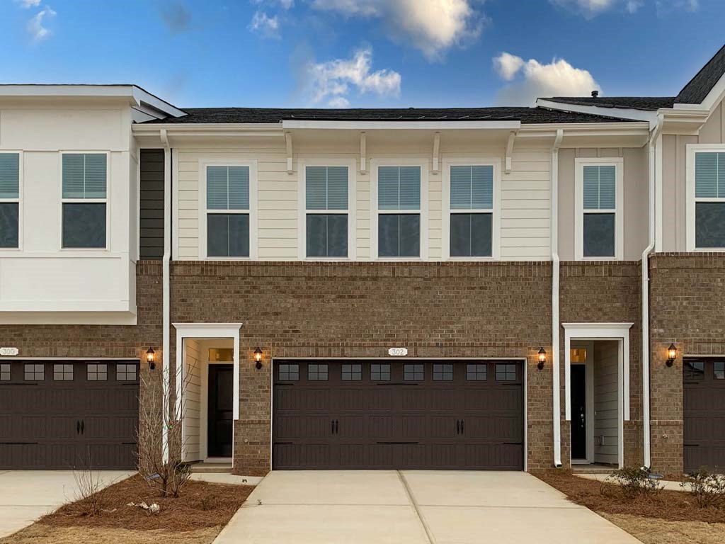 an image of a brick house with two garage doors