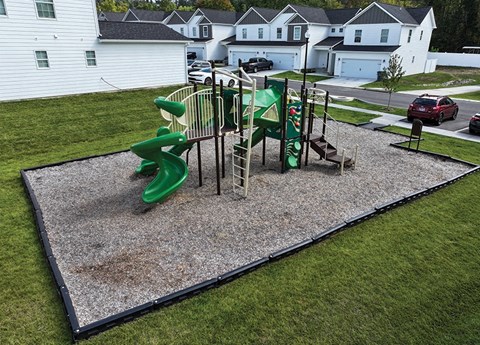 A playground with a green slide and a climbing structure.