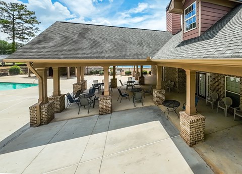 A covered patio area with a table and chairs.
