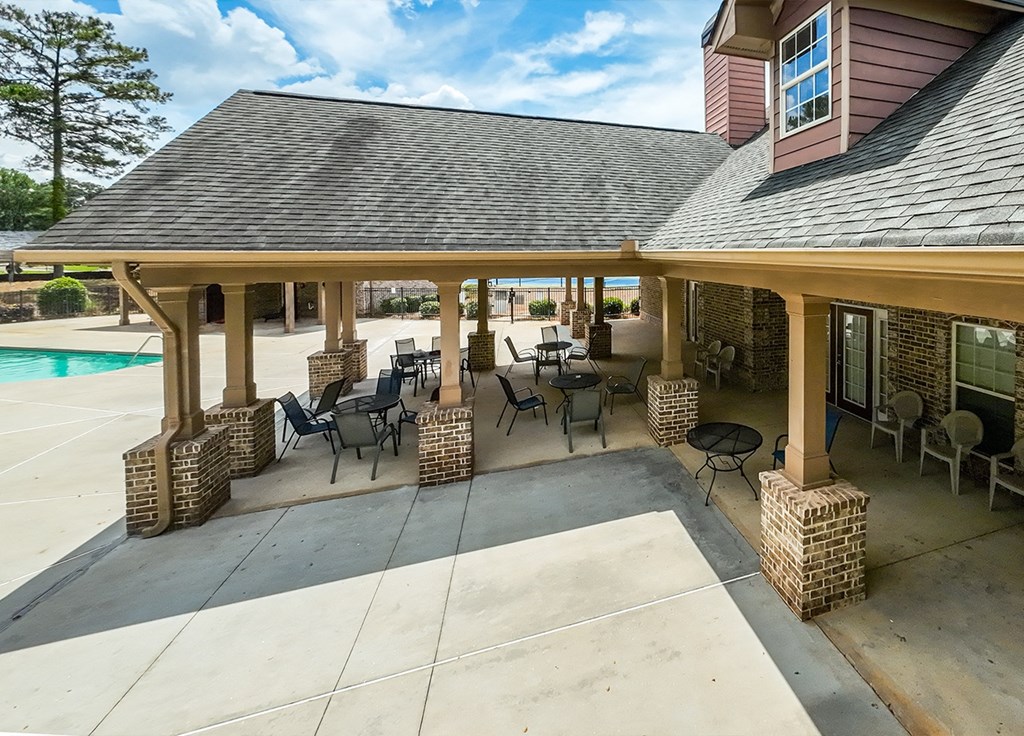 A covered patio area with a table and chairs.