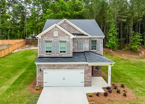 A house with a grey roof and a white garage door.